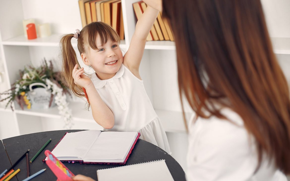 cute schoolgirl doing homework with help of tutor BACK TO SCHOOL ANXIETY - ADVICE FOR PARENTS FROM EXPERTS