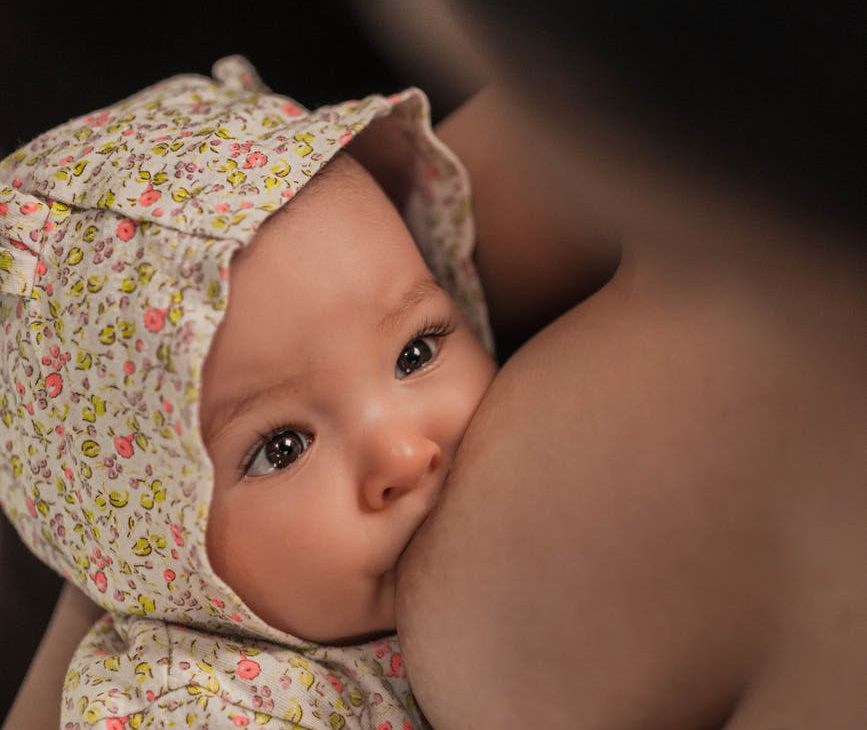unrecognizable woman suckling cute newborn child MOTHERHOOD & WELLNESS