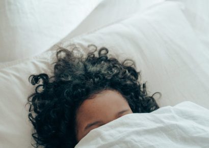 unrecognizable person sleeping under blanket