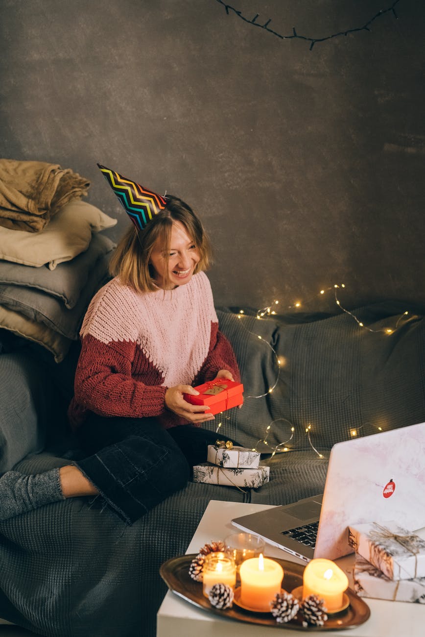 woman holding a gift while having a video chat